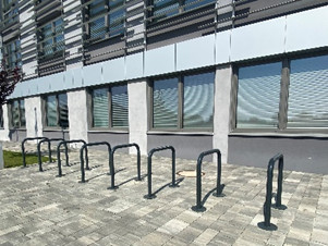 Przed budynkiem znajdują się stojaki rowerowe.